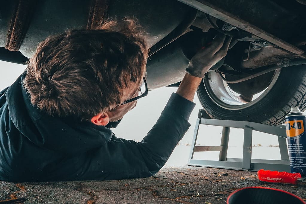 Auto mechanic inspecting a car with recurring issues possibly qualifying as a lemon