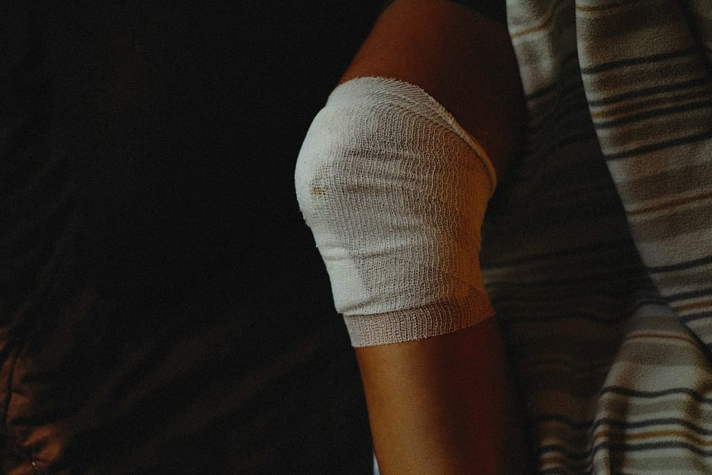 Injured person's knee wrapped in medical gauze after a slip and fall accident