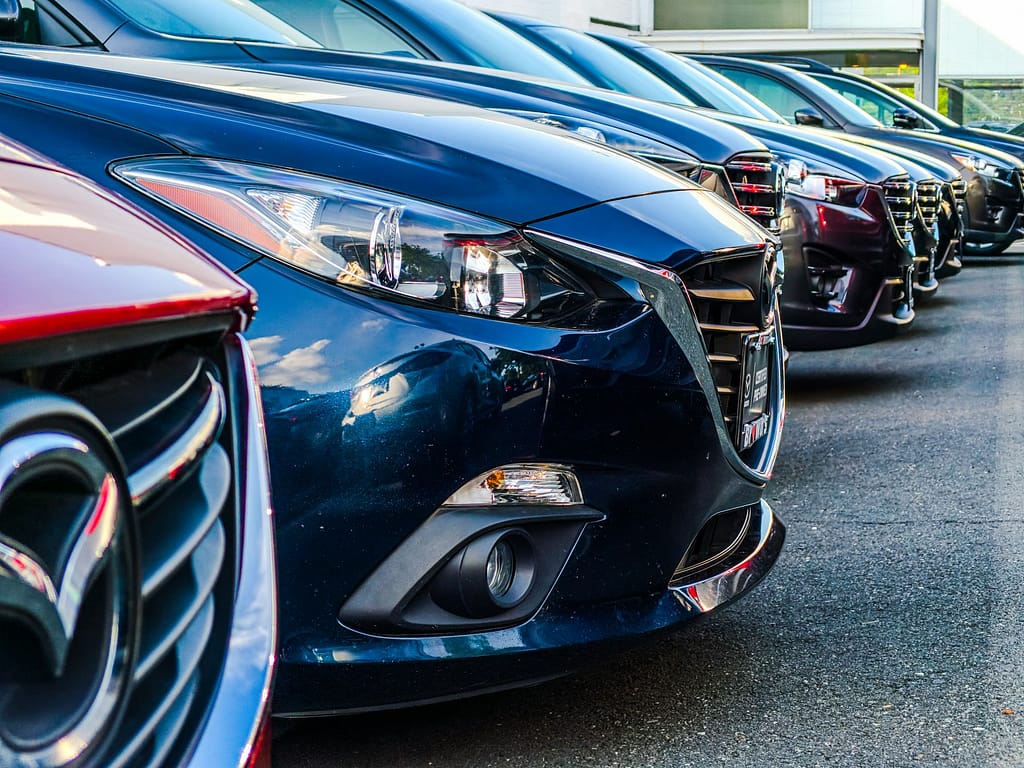 Row of new cars parked at a dealership showroom, representing vehicles eligible for California Lemon Law coverage