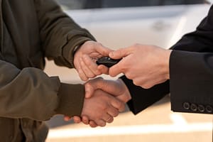 Driver handing car keys back during a lemon law refund or buyback.