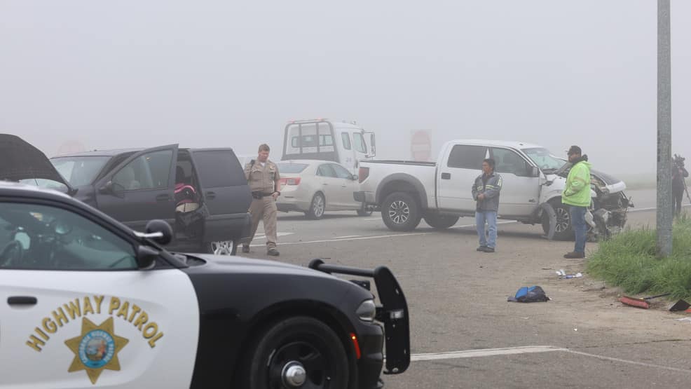 CHP officers and damaged vehicles at the scene of a fog-related crash in California
