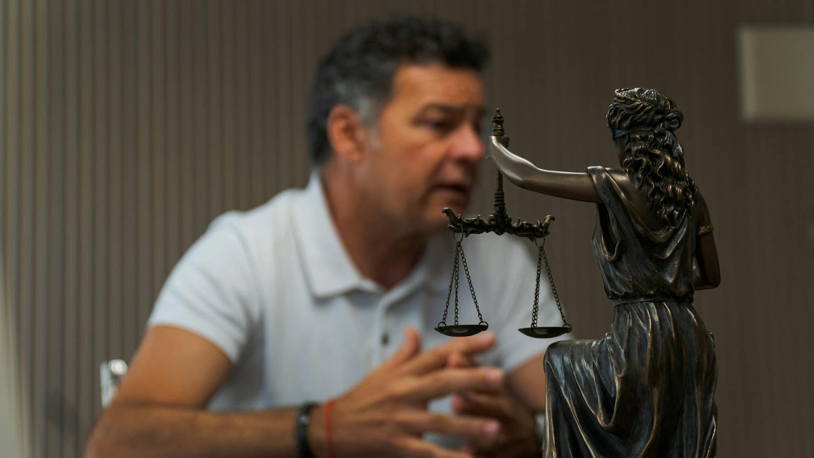 Lawyer discussing legal options with a client, with Lady Justice statue in the foreground—symbolizing legal support after a car accident.