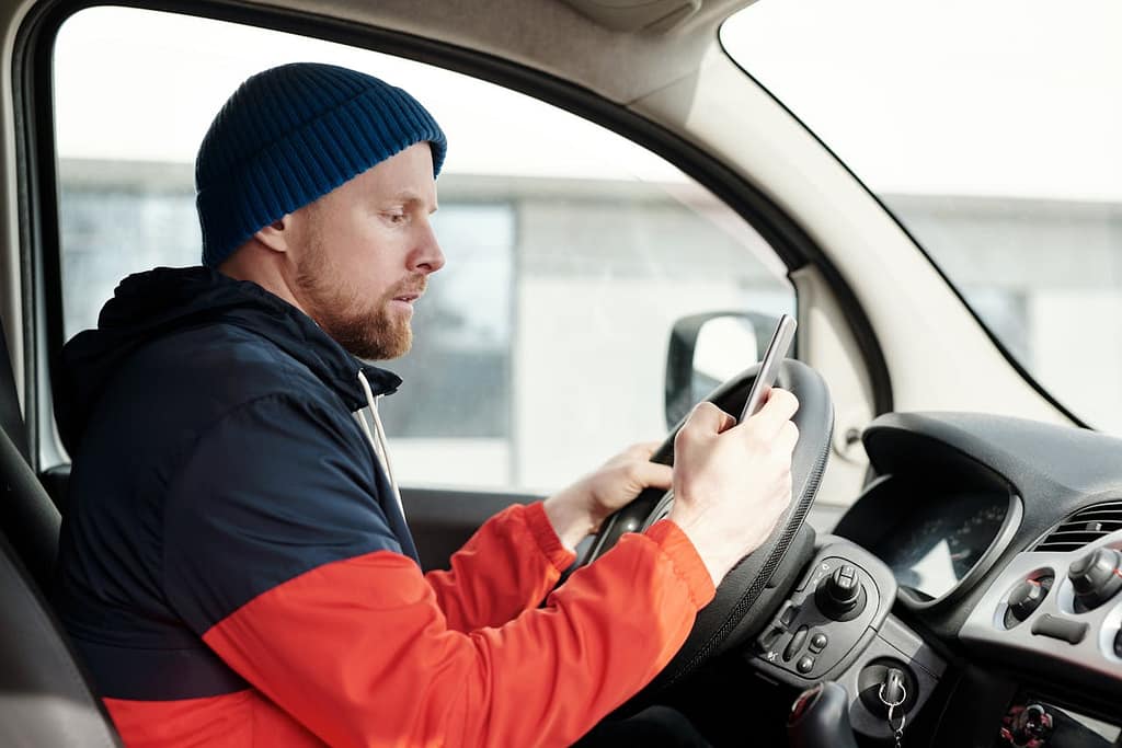 Driver using a smartphone behind the wheel – example of negligence in car accidents due to distracted driving.